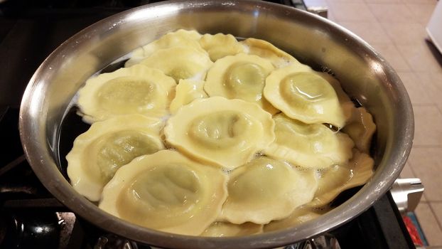 ravioli spinach pasta cooking in pot of hot water on stove