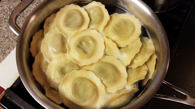 ravioli spinach pasta cooking in pot of hot water on stove