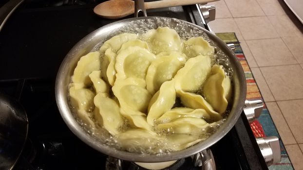 ravioli spinach pasta cooking in pot of boiling hot water on stove