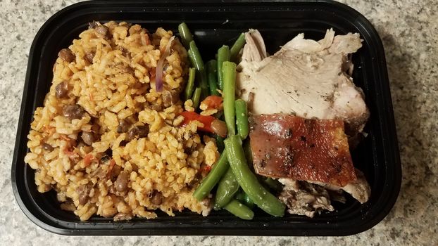 Puerto Rican pork and rice and beans in container on counter