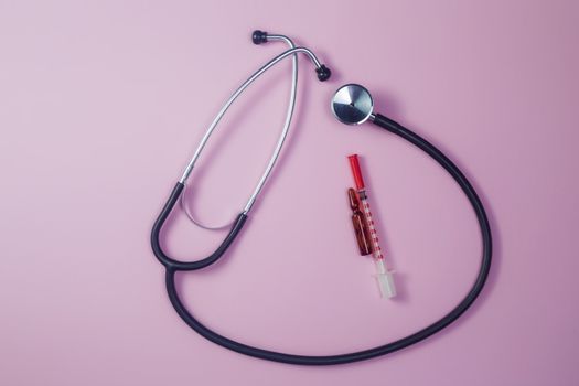 Covid-19, coronavirus treatment. Pills, stethoscope and medical masks, vaccine on pink background.