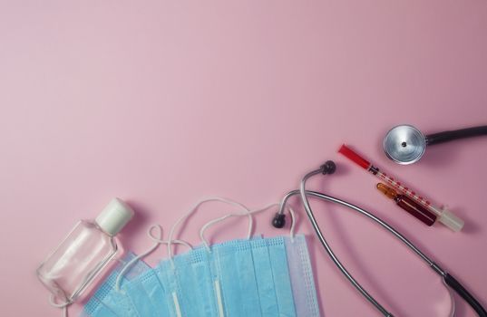 Covid-19, coronavirus treatment. Pills, stethoscope and medical masks on pink background.