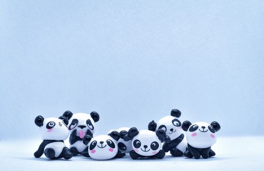 Little panda porcelain figurines isolated on black background