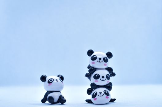 Little panda porcelain figurines isolated on black background