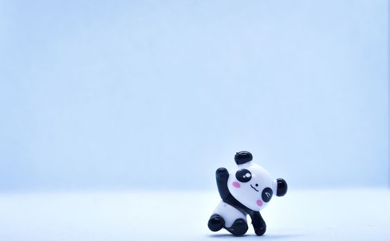 Little panda porcelain figurine isolated on black background