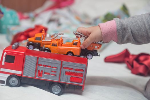 A child plays with cars that he just received as a gift.