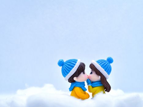 Tourism and travel concept: Miniature people kissing each other in winter snow