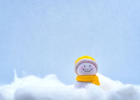 Tourism and travel concept: Miniature little snowman standing alone in winter snow