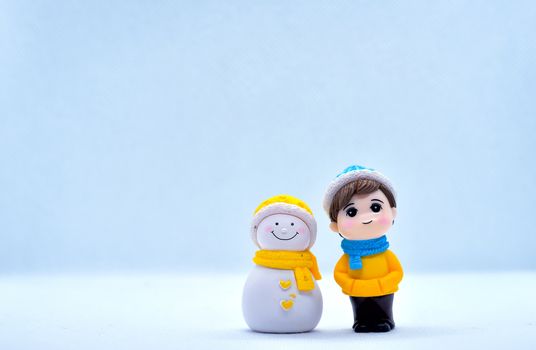 Tourism and travel concept: Miniature little boy and snowman standing in isolated background