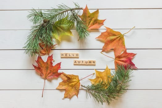 Frame made of autumn fallen leaves on wooden background.