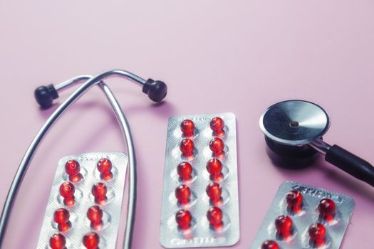 Covid-19, coronavirus treatment. Pills, stethoscope and medical masks on pink background.