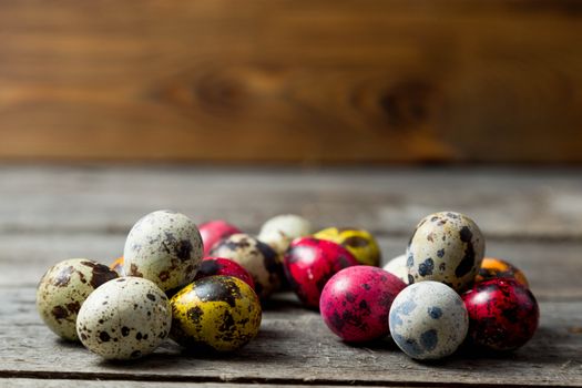 Painted easter eggs in small groups on wooden background. Easter background