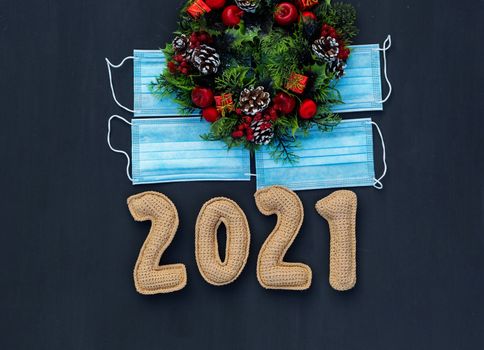 .New year in the context of coronavirus knitted numbers 2021 on medical mask on chalk board