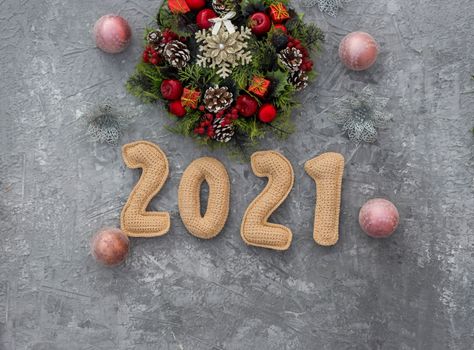 .Christmas background with knitted numbers 2021 and decorative wreath