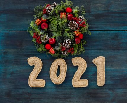 .Christmas background with knitted numbers 2021 and decorative wreath