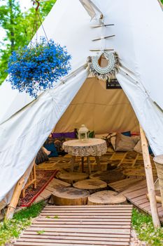 A tent in a summer cafe in a green park. Themed hipster cafe in the city park.