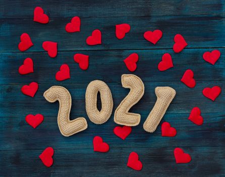 Romantic christmas background with knitted number 21 and red hearts, pandemic new year