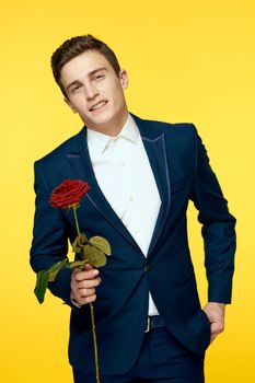 Gentleman in classic suit on yellow background with red rose romance cropped view. High quality photo