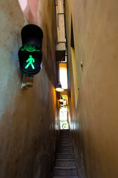 The architecture of the strago city of Prague. The narrowest street in Europe. The passage between buildings for one person, regulated by traffic lights.