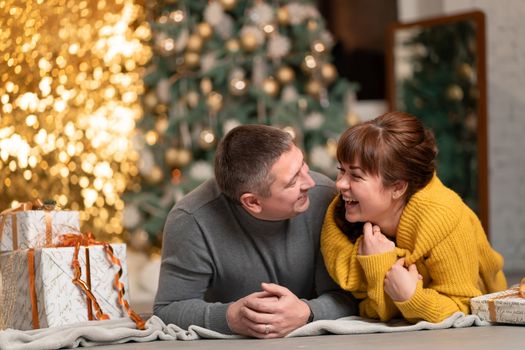 A beautiful cheerful couple greets the Christmas holidays in a cozy home atmosphere.