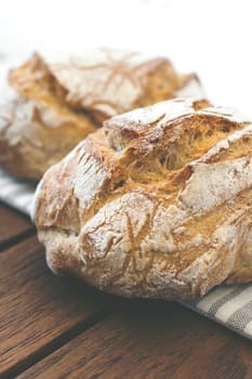 Close-up of rustic Italian bread, isolated on background out of focus.