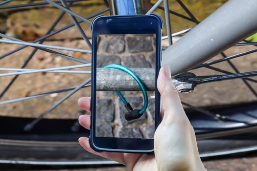 Bicycle robbery composing of a female hand holding a smartphone taking a picture