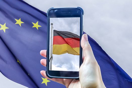 German flag in a smartphone display in front of a european union flag