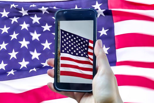 USA flag in a smartphone display in front of a big USA flag