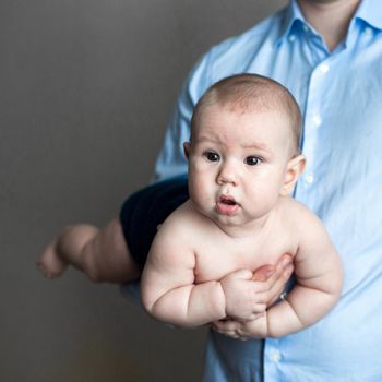 close-up portrait of a toddler boy in the arms of dad