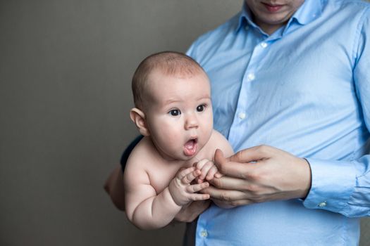 close-up portrait of a toddler boy in the arms of dad