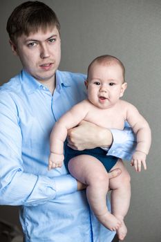 close-up portrait of a toddler boy in the arms of dad