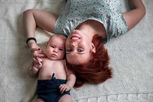 close-up portrait of mom and baby lying on the floor.