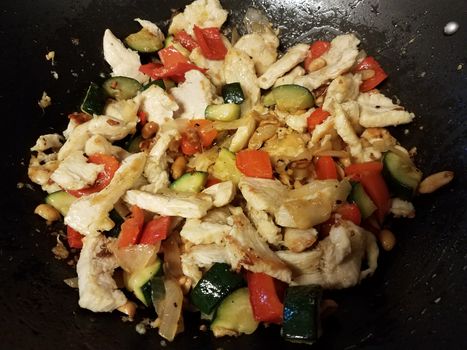 Chinese food chicken and red pepper and vegetables cooking in wok