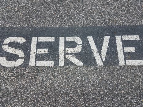 white serve letters painted on black asphalt or pavement