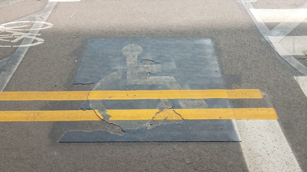 old wheelchair sign with yellow lines painted over
