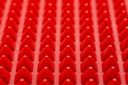 abstract red silicone pyramids mat close-up background.
