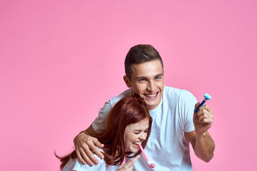 enamored man and woman hugging each other on a pink background cropped with Copy Space family portrait. High quality photo