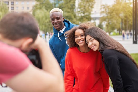 Multi ethnic friends outdoor on photo shooting looking at camera. Diverse group people Afro american asian spending time together Multiracial male female student meeting outdoors for photo