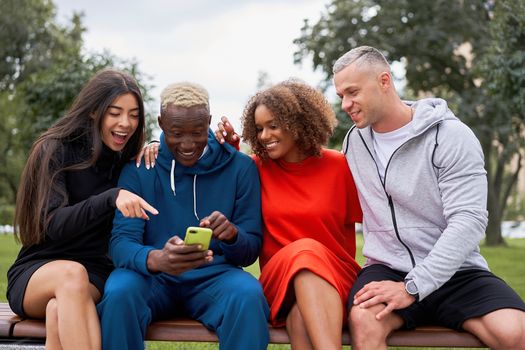 Multi ethnic friends outdoor looking smartphone screen. Diverse group people Afro american asian caucasian spending time together Multiracial male female student meeting outdoors