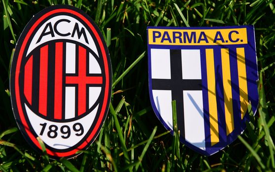 September 6, 2019, Turin, Italy. Emblems of Italian football clubs Milan and Parma on the green grass of the lawn.