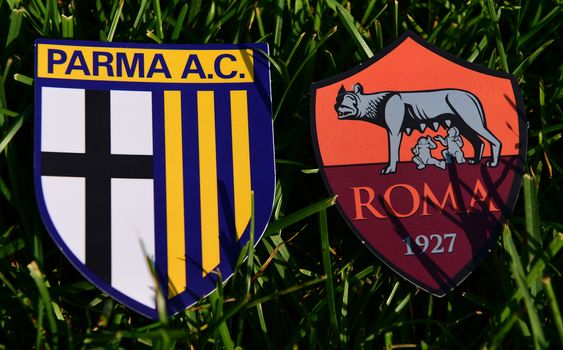 September 6, 2019, Turin, Italy. Emblems of Italian football clubs Parma and Roma on the green grass of the lawn.