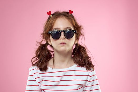 Cute girl sunglasses striped t-shirt lifestyle fun style pink background. High quality photo