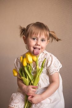  A Portrait of a beautiful little girl with a bouquet of yellow tulips flowers by 8th march international womens day