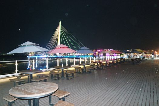 Night view of a beautiful scene of bridge over sea water in the evening time with colorful lights.