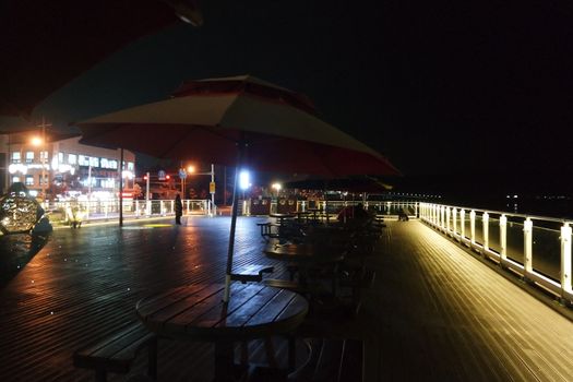 Night view of a beautiful scene of bridge over sea water in the evening time with colorful lights.