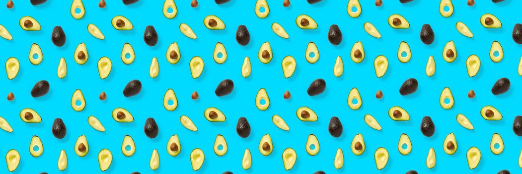 Avocado banner. Background made from isolated Avocado pieces on blue background. Flat lay of fresh ripe avocados and avacado pieces