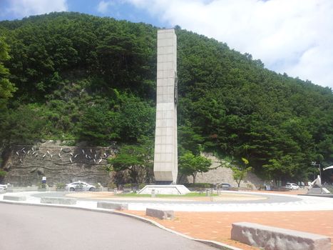 Monument minerate of soyang dame with green mountains and bluse sky in the background. This monumet is in Chuncheon city of South Korea.