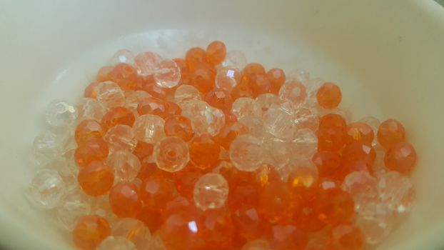 Shining, transparent, orange color crystal beads or gemstones or amber beads in a bowl