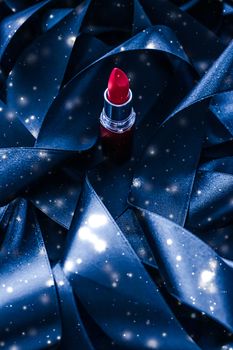 Red lipstick on blue silk and shiny glitter background, luxury make-up and beauty cosmetics