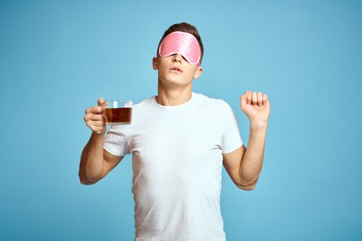 man with pink sleep mask and cup of tea drink cheerfulness model breakfast. High quality photo